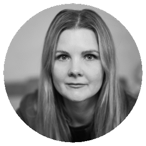 Black and white portrait of Ailsa Paterson, a woman with long, straight hair, looking directly at the camera with a neutral expression. The photo is framed in a circular shape.