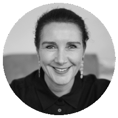 Black and white portrait of Rebecca Pearce, a woman with dark hair pulled back, wearing earrings and a collared shirt, smiling warmly while looking directly at the camera.